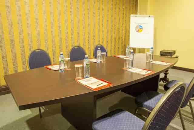 Boardroom at Phoenicia Hotels, small conference setup with dated decor for corporate events.