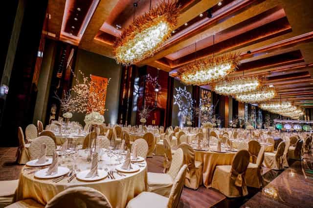 Luxury ballroom in Sala Verdi with gold decor and floral centerpieces for gala or wedding events.
