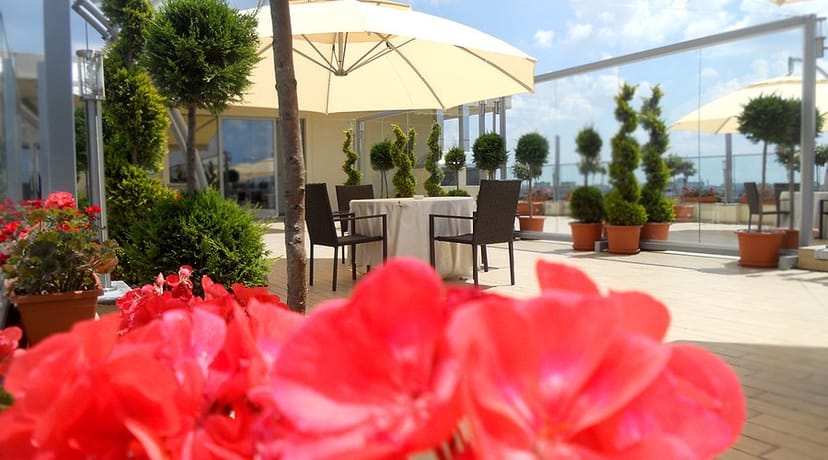 Rooftop restaurant with parasol seating for networking events and corporate brainstorming.