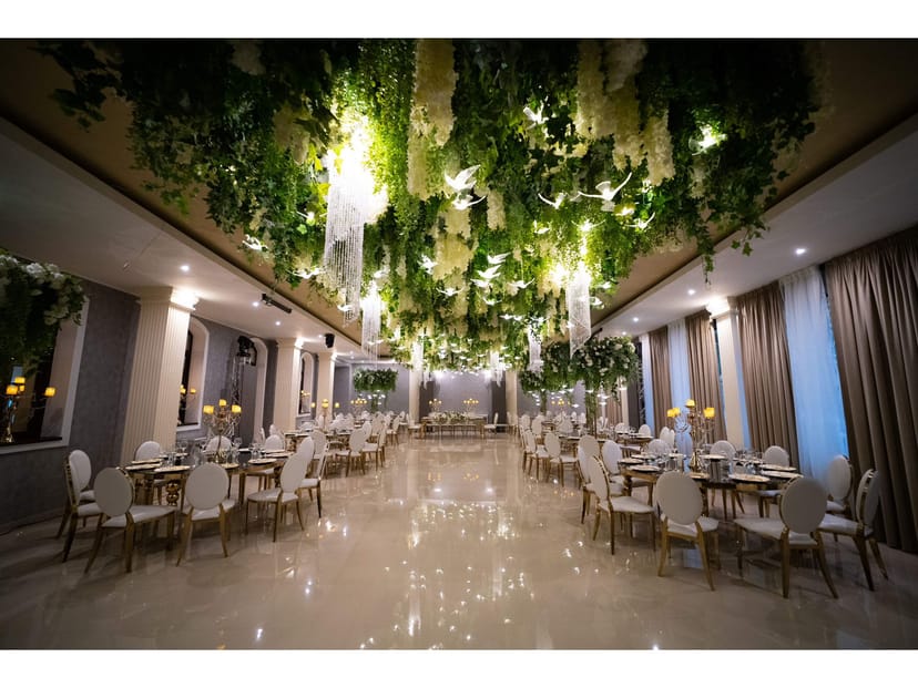 Secret Garden gala venue featuring immersive floral ceiling decor and dramatic event lighting.