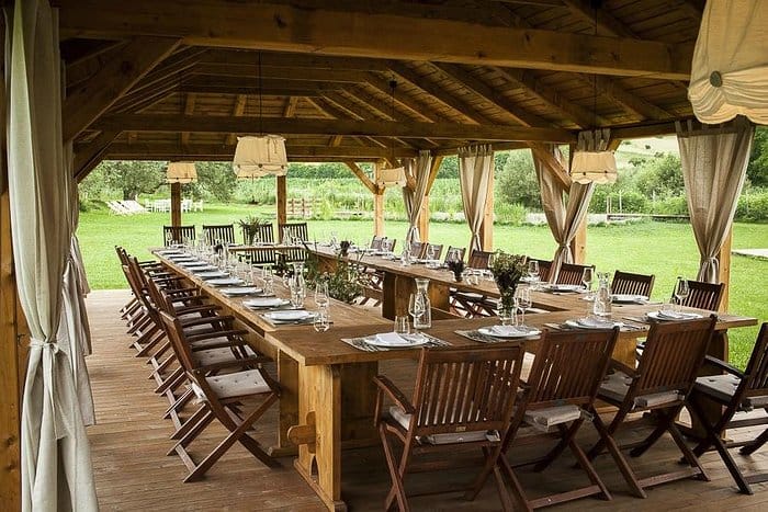 U-shaped banquet setup in rustic Valea Verde pavilion for corporate retreats and al fresco dining.