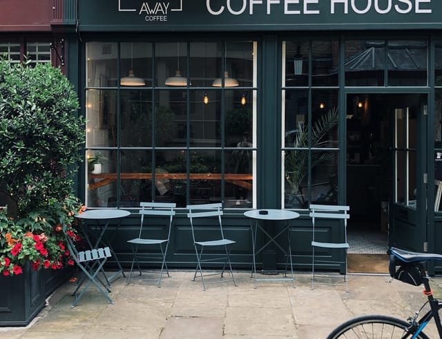 Cozy urban café exterior, perfect for VIP networking and event breakout sessions.