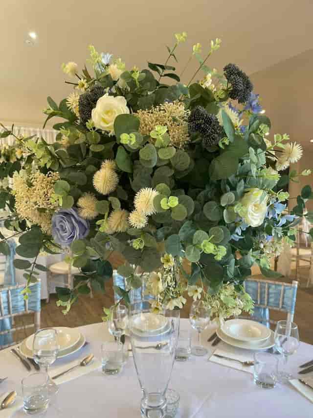 Dusty blue rose and eucalyptus centerpiece for wedding and event tablescapes.