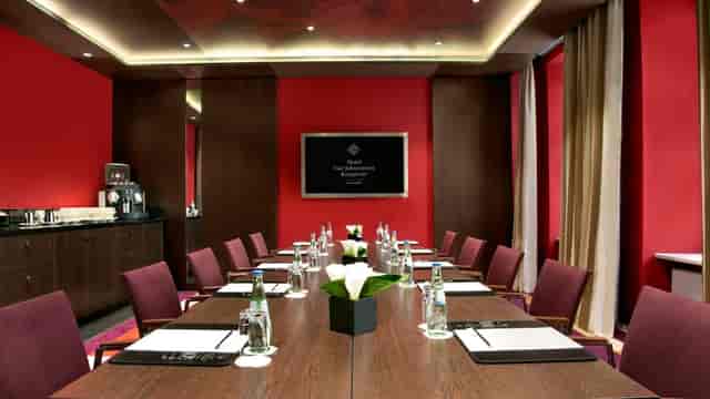 Modern conference room with red walls in Hotel Vier Jahreszeiten Kempinski, Munich, ideal for meetings.