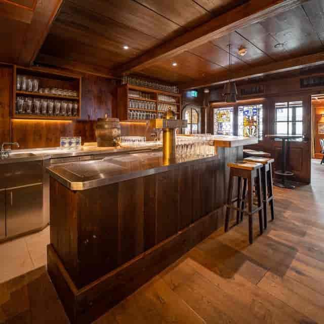 Cozy Bierkutscher-Stube bar with rustic wood finishes for networking events and gatherings.
