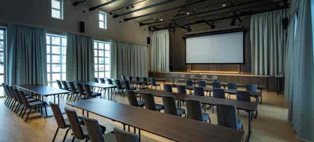 Wirtsgarten meeting space with flexible seating and large screen for events in Marias Platzl.