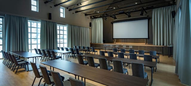 Wirtsgarten meeting space with flexible seating and large screen for events in Marias Platzl.