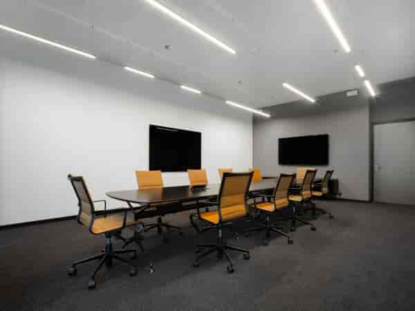 Modern executive boardroom with orange chairs for corporate strategy and business meetings.
