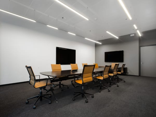 Modern executive boardroom with orange chairs for corporate strategy and business meetings.