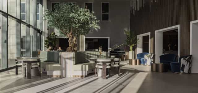 Upscale hotel lobby with greenery and piano for corporate events and VIP networking.