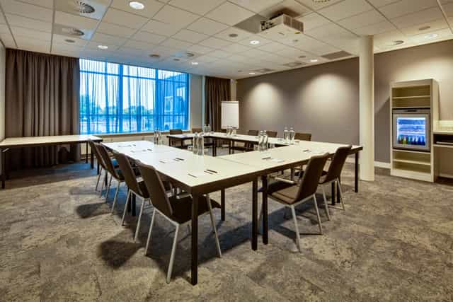 U-shaped meeting room with natural light, perfect for collaborative workshops and board meetings.