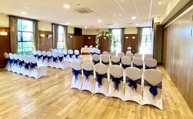 Emerald Room wedding venue with floral arch and theater-style seating.