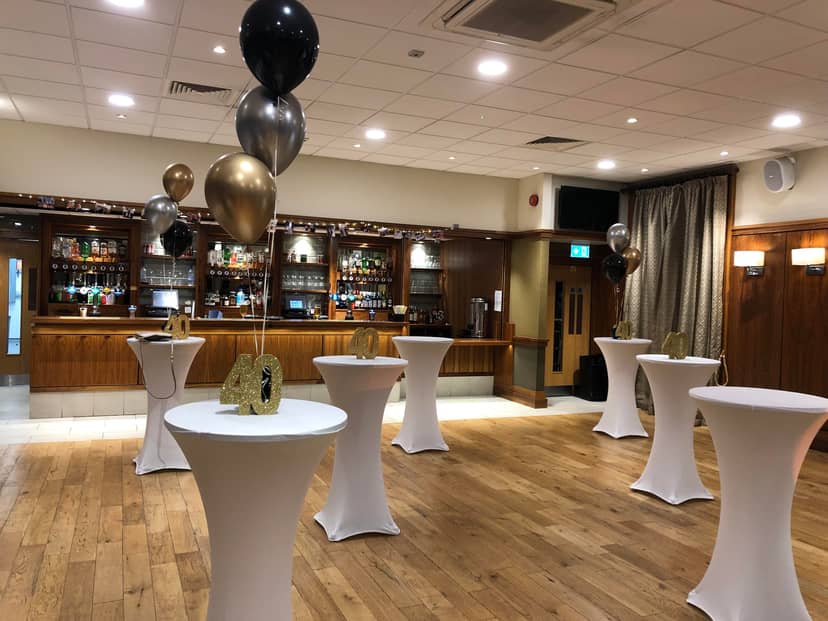 Cocktail-style reception in Emerald Room with balloon centerpieces for milestone birthday events.