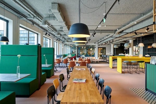 Modern Aristo Amsterdam breakout space with booths and tables for corporate networking workshops.