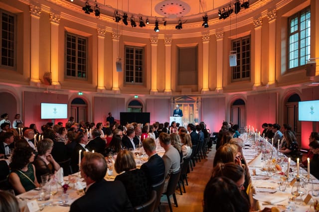 Felix Meritis concert hall banquet setup with communal tables for corporate events and conferences.