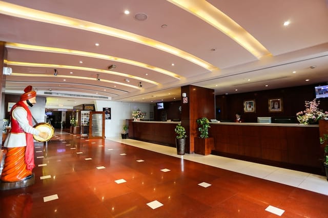 Spacious Ramee Royal Hotel lobby with long reception desk for corporate events and conferences.