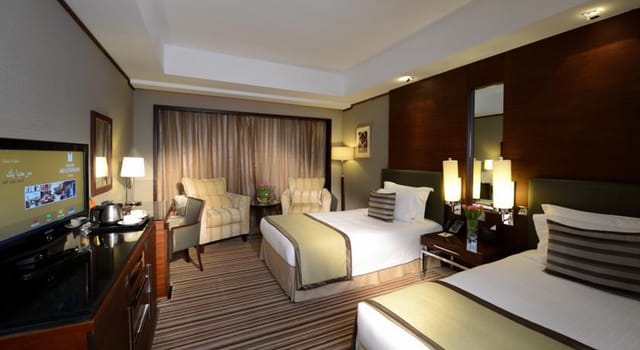 Twin-occupancy hotel suite at Grand Millennium Dubai for business conferences and group housing.
