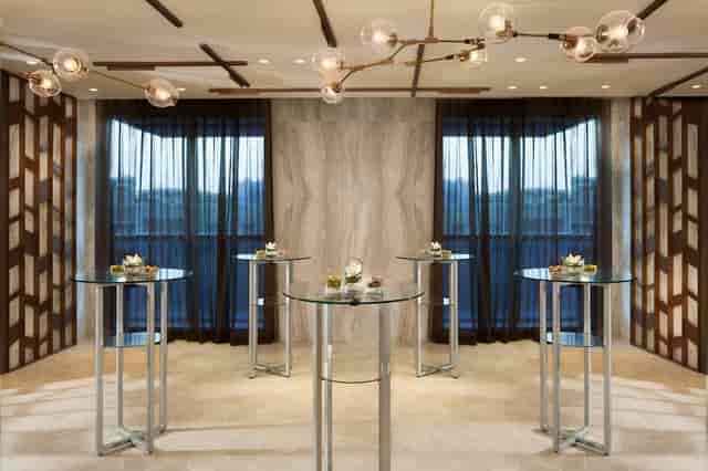 Ballroom pre-function reception area with sleek cocktail tables for corporate networking events.