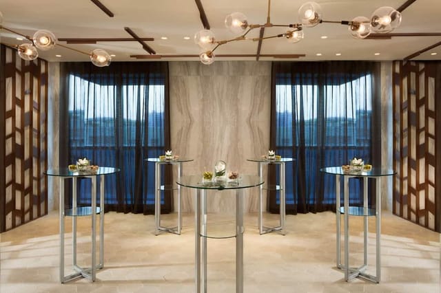 Ballroom pre-function reception area with sleek cocktail tables for corporate networking events.