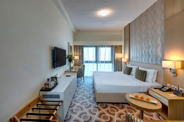 Hotel guest room at Metropolitan Dubai with workspace for business conferences and corporate events.