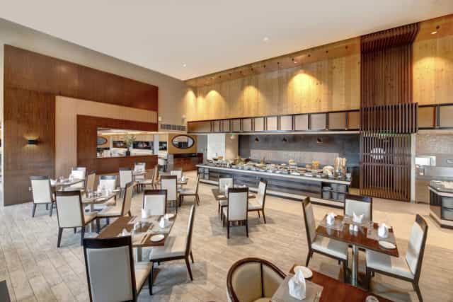 Modern restaurant buffet dining area at Metropolitan Hotel Dubai for business events.
