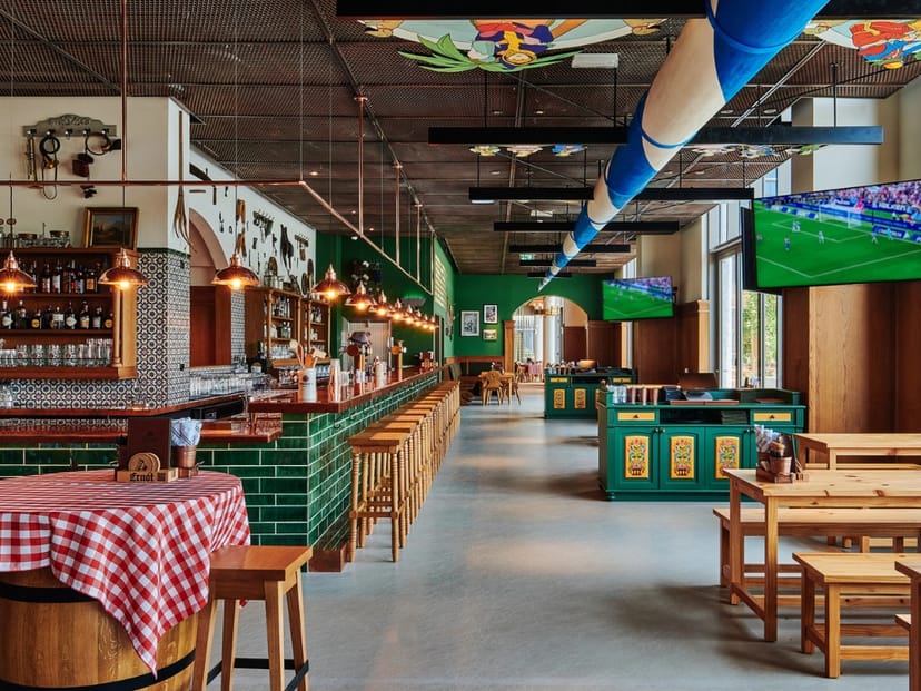 ERNST at 25hours Hotel: Versatile event space with communal tables for networking and sports events.