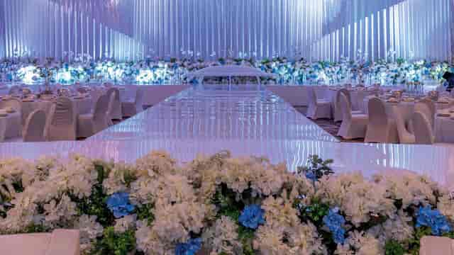 Luxury ballroom gala setup with reflective runway and floral decor for high-end wedding events.