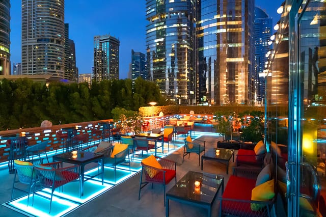 Rooftop cocktail reception at Gemino, Dubai featuring LED flooring and urban skyline.