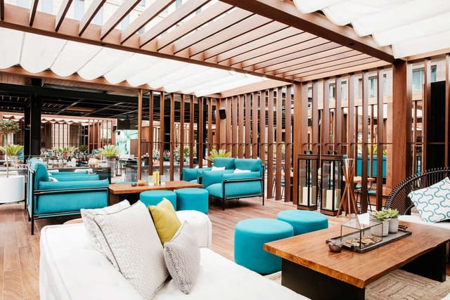Outdoor breakout space with teal lounge seating for corporate networking and VIP hospitality.