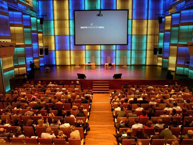 "Conference auditorium with engaged audience and modern lighting for impactful events"