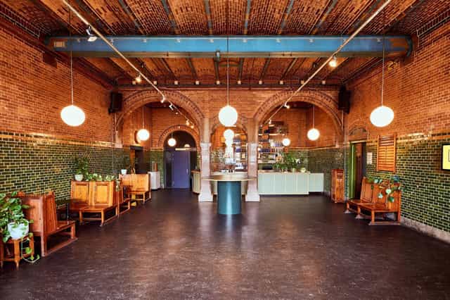 Stylish Lotenzaal event space with exposed brick walls and warm lighting for gatherings.