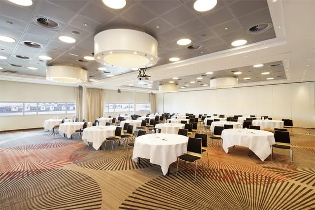 Versatile ijVENUES ballroom with round tables for corporate conferences and banquet events.