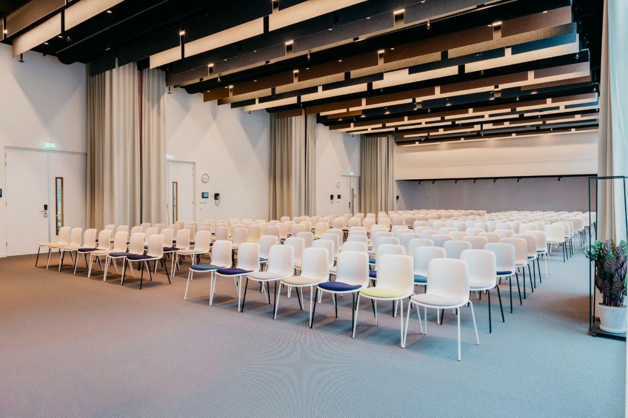 Conference room at Hotel Casa Amsterdam with white chairs for meetings and workshops.