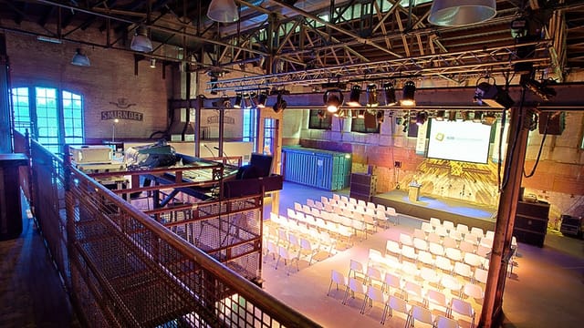 Large hall in Transformatorhuis with organized seating for conferences and meetings.