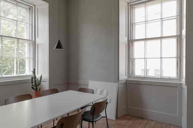 Modern minimalist meeting room with natural light, ideal for small team gatherings.