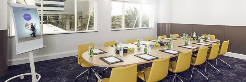 MAS Meeting Room at Novotel Bur Dubai with yellow task chairs for professional board meetings.