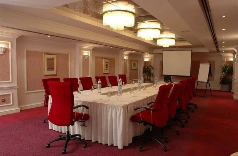 Boardroom at Riviera Hotel Dubai with red chairs for corporate meetings and business conferences.