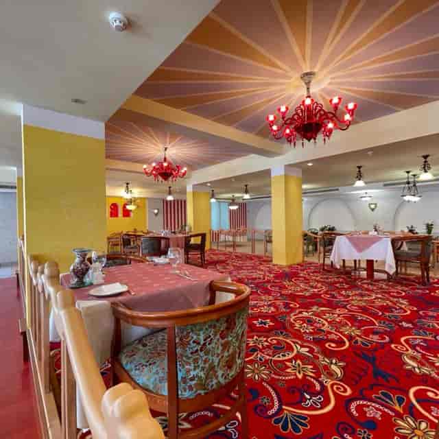 Riviera Hotel Dubai ballroom with vibrant red chandeliers for corporate events and gala dinners.