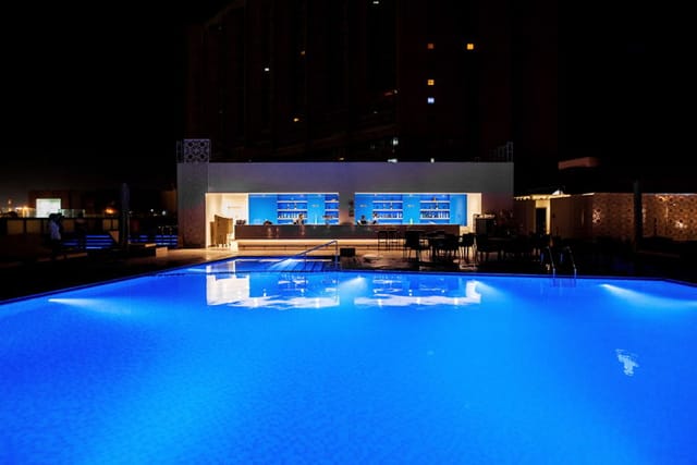 Sophisticated poolside evening reception bar at Radisson Blu Dubai for networking events.