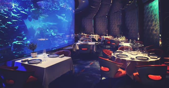 Private dining room at Burj Al Arab with aquarium backdrop for gala dinner or VIP reception.