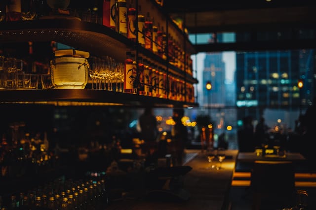 VIP networking reception at Clap Restaurant & Bar with moody lighting and urban skyline views.