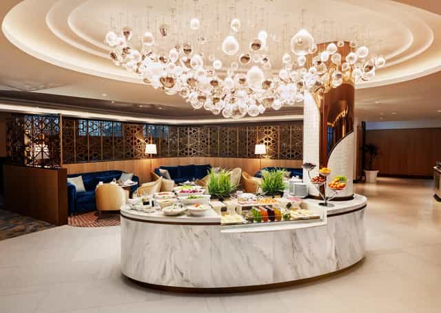 Executive Lounge with marble buffet and chandelier for VIP networking and corporate events.