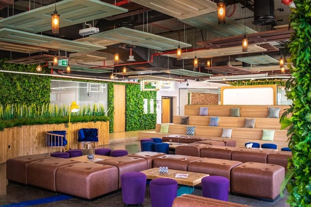 Biophilic breakout space with tiered seating for agile workshops and office networking.