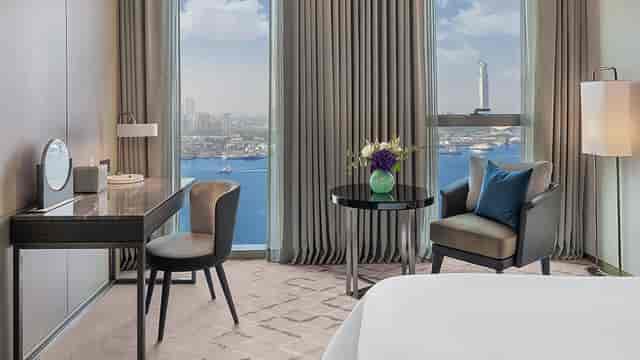 Executive guest room at Qix Teens with waterfront view for VIP events and speaker workspace.