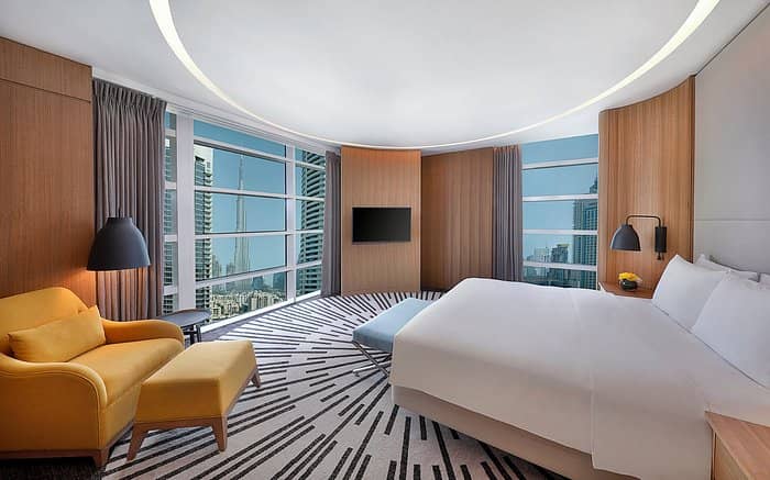 Contemporary DoubleTree Dubai suite with skyline view for executive business travel and events.