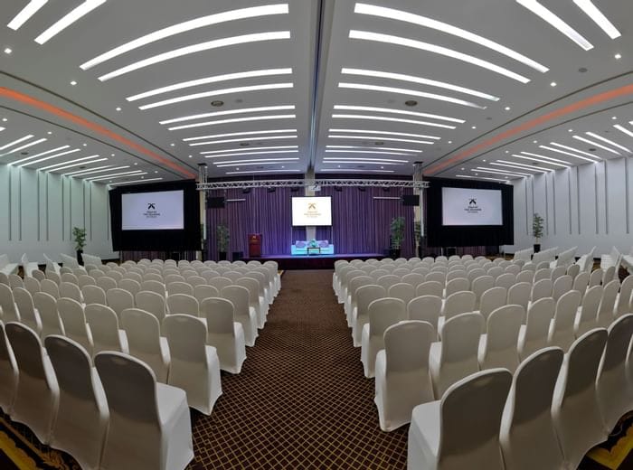 Theater-style conference room at Two Seasons Hotel with triple screens for corporate events.