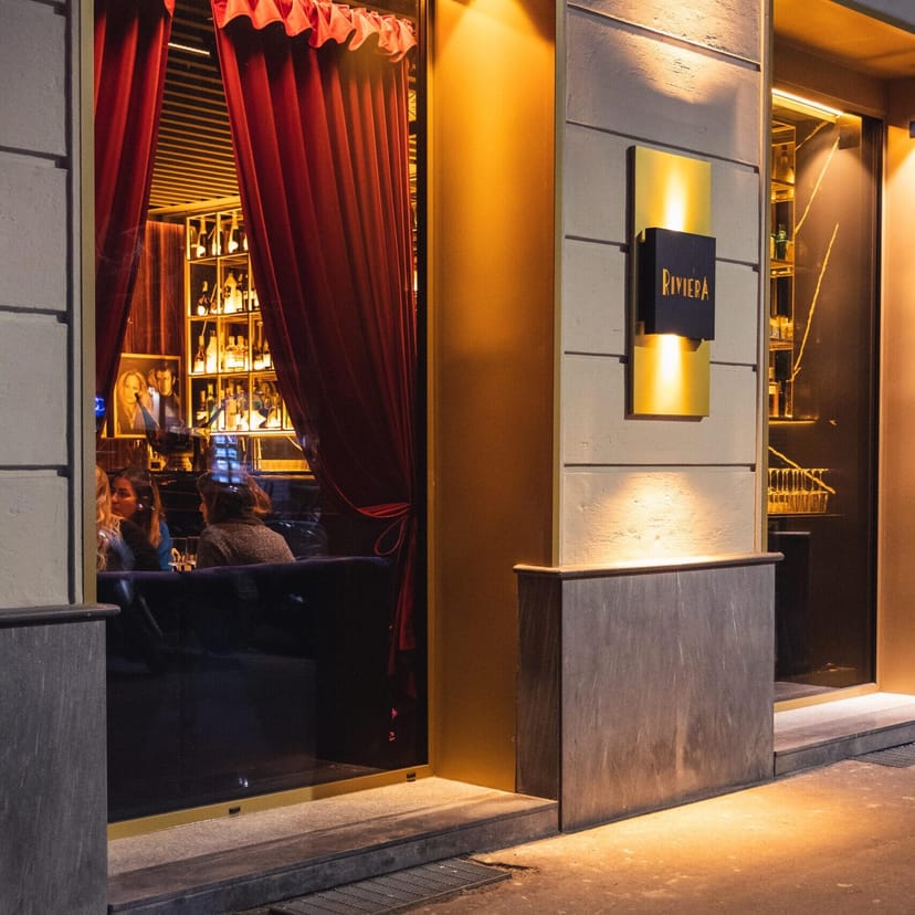 Upscale Milan restaurant entrance with red velvet drapes for VIP receptions and networking events.