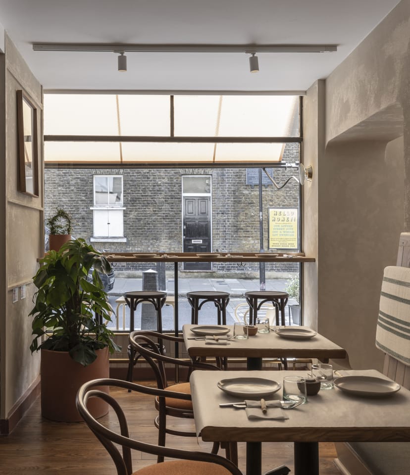 Private dining room at Honey & Co with bistro tables for boutique corporate event networking.