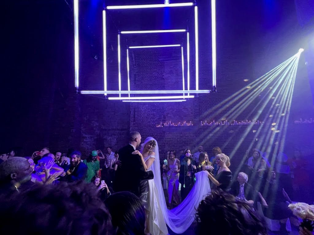 Wedding reception couple dancing under geometric lights at Village Underground.