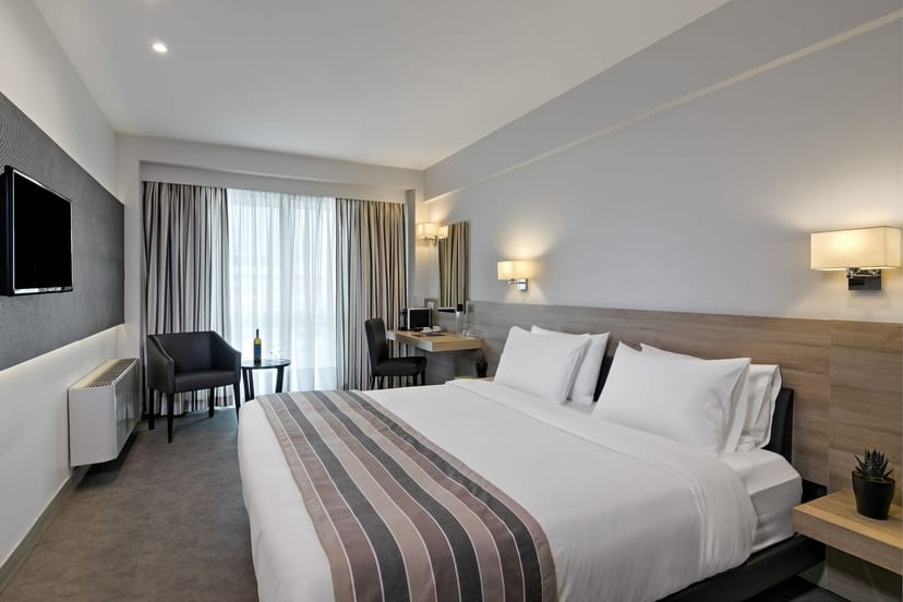 Aoos contemporary guest room with workspace for corporate travel and business events.